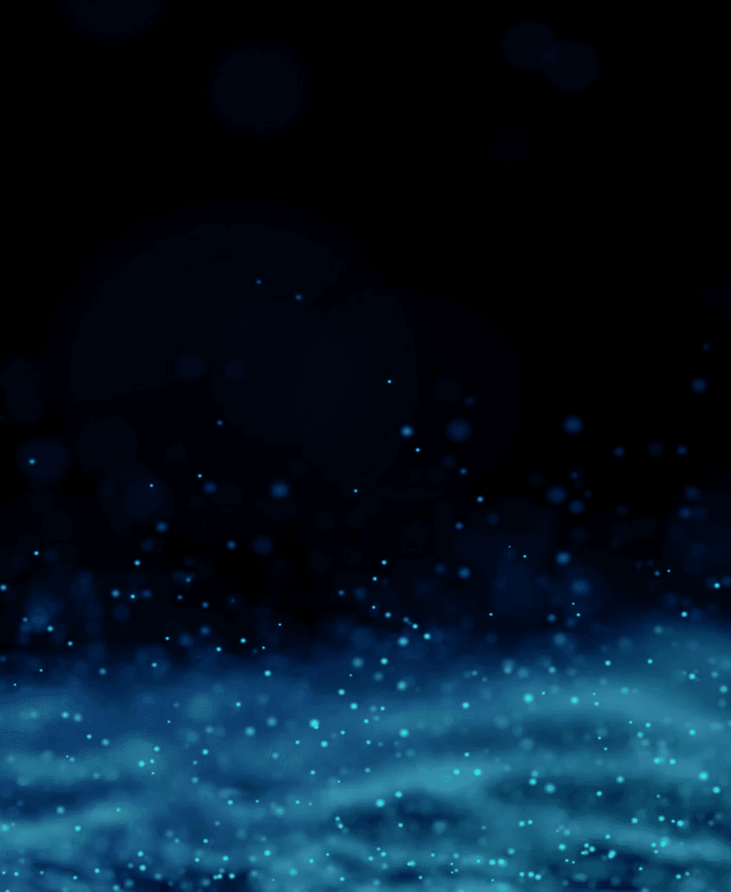 Close-up portrait of a person wearing a gray insulated hooded jacket with the hood up, showing their face framed by the hood against a light background.