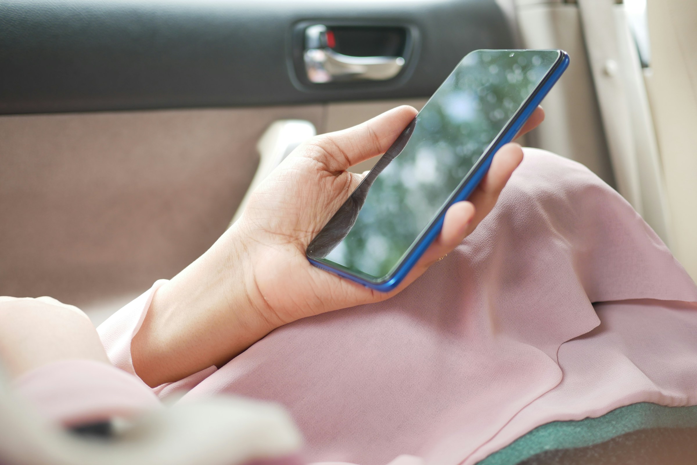 person in car looking at mobile - Shopify Mobile Optimization