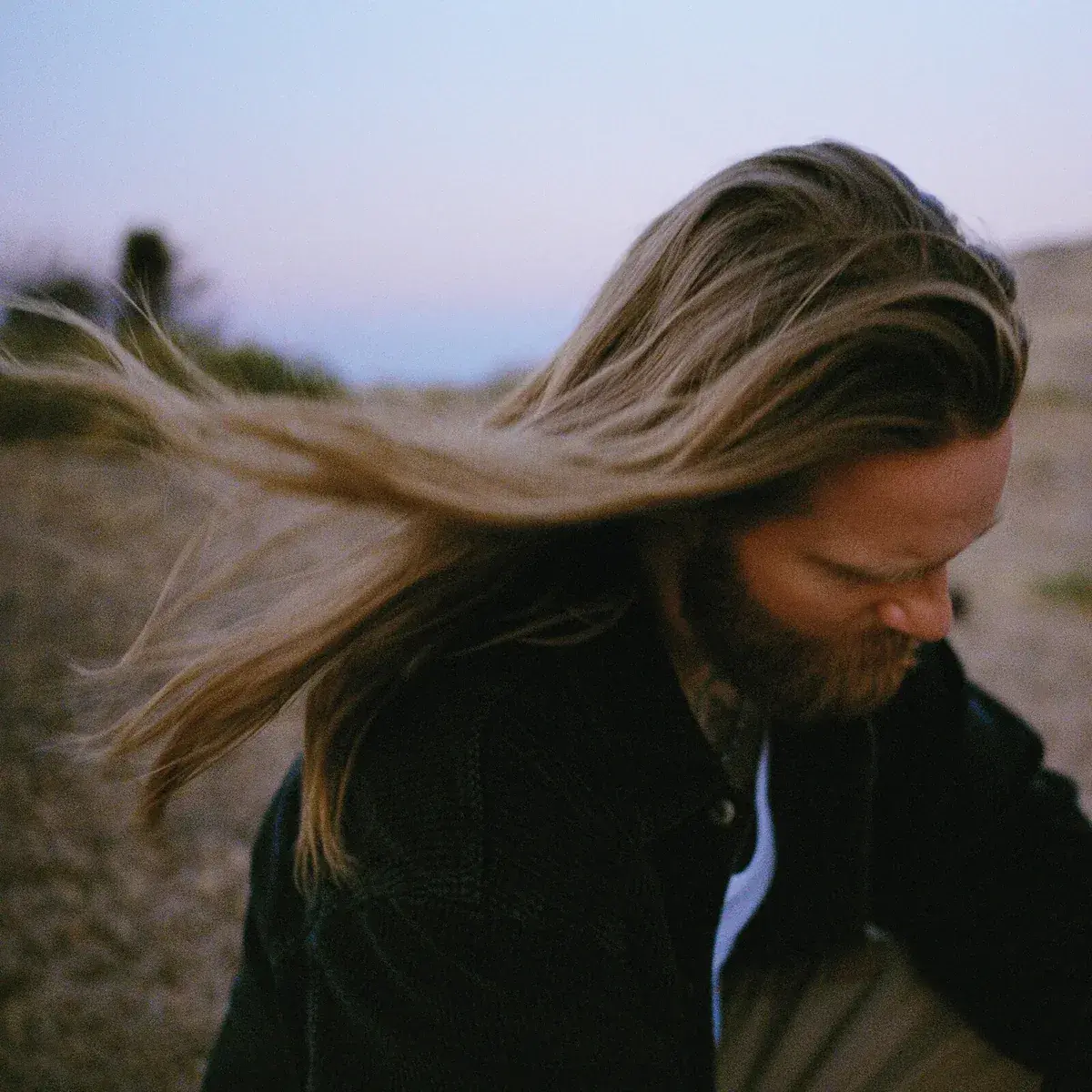 A modern brick house with a two-car garage, well-manicured lawn, and clear blue sky in the background.