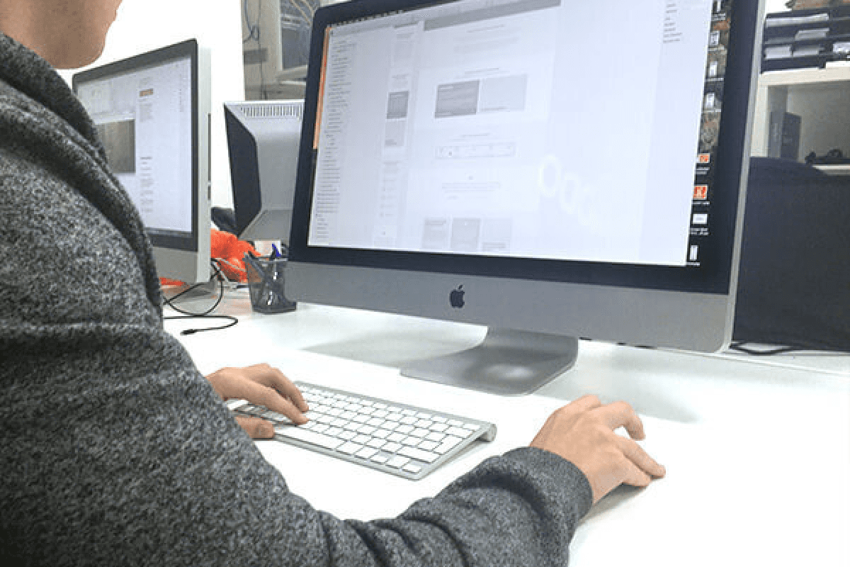 An over the shoulder shot of a software engineer working at a computer