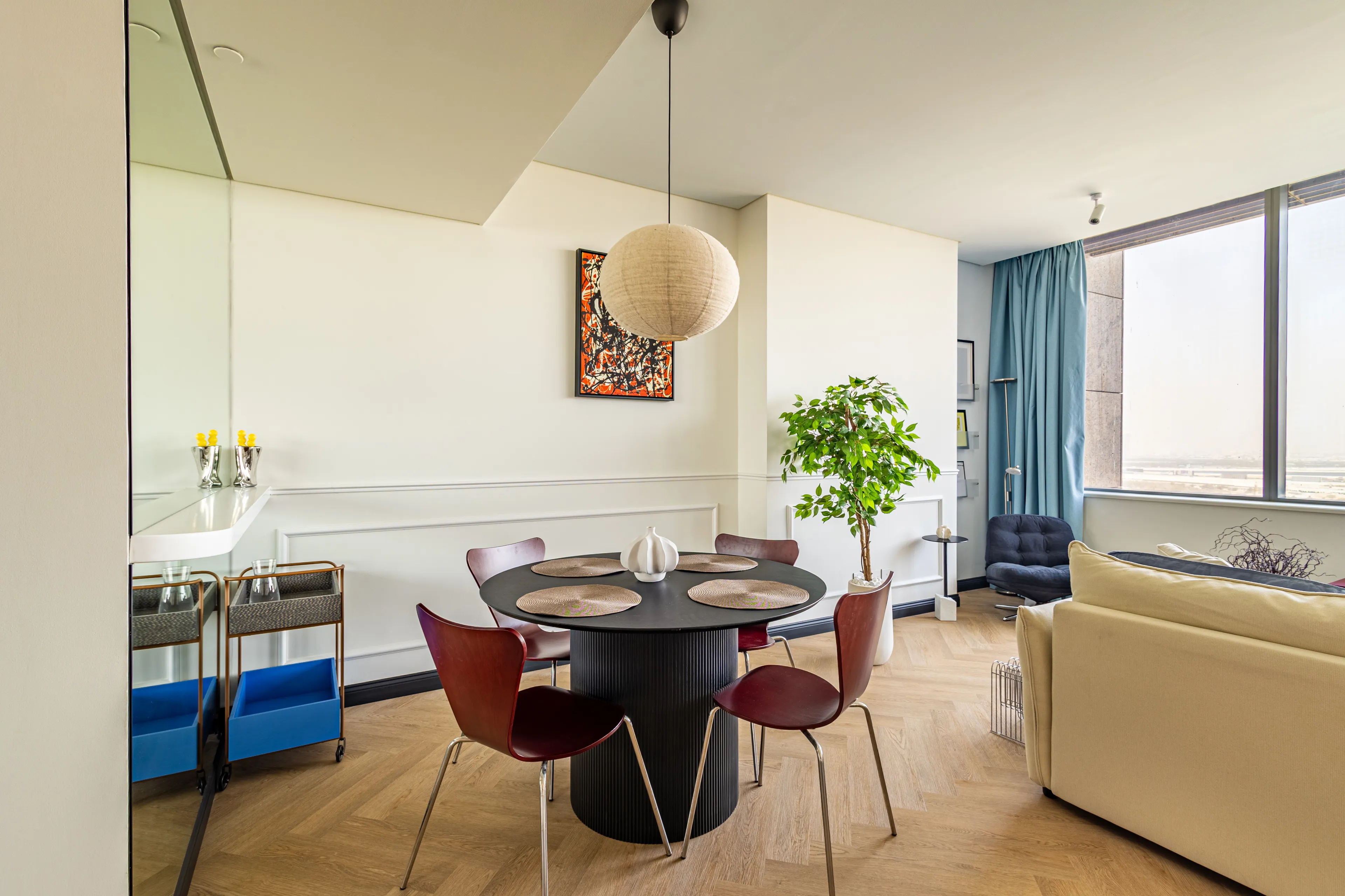 Minimal yet colourful side of the dining room with a big lamp.