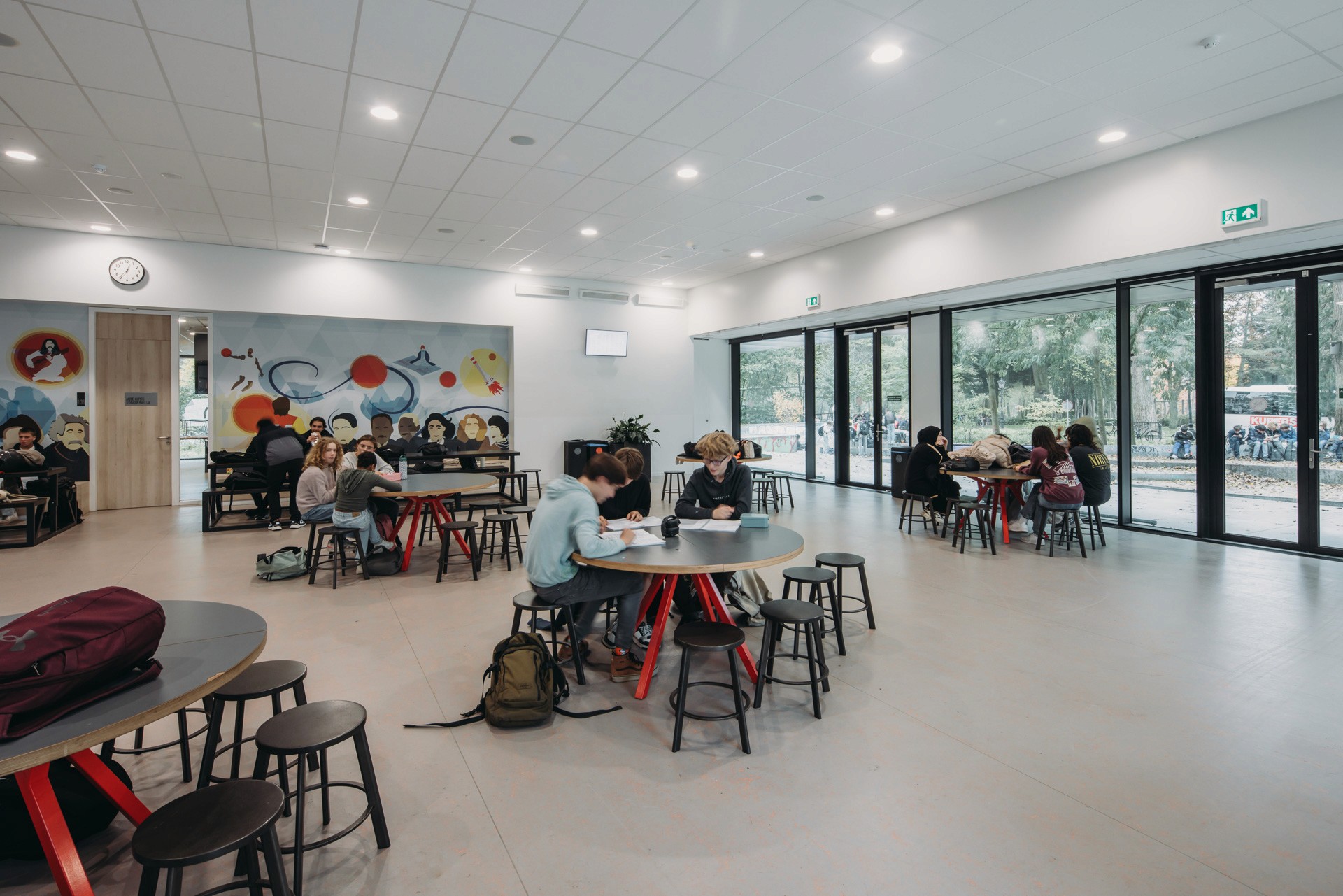 Interior photo of the main aula, with kids working in groups on the tables