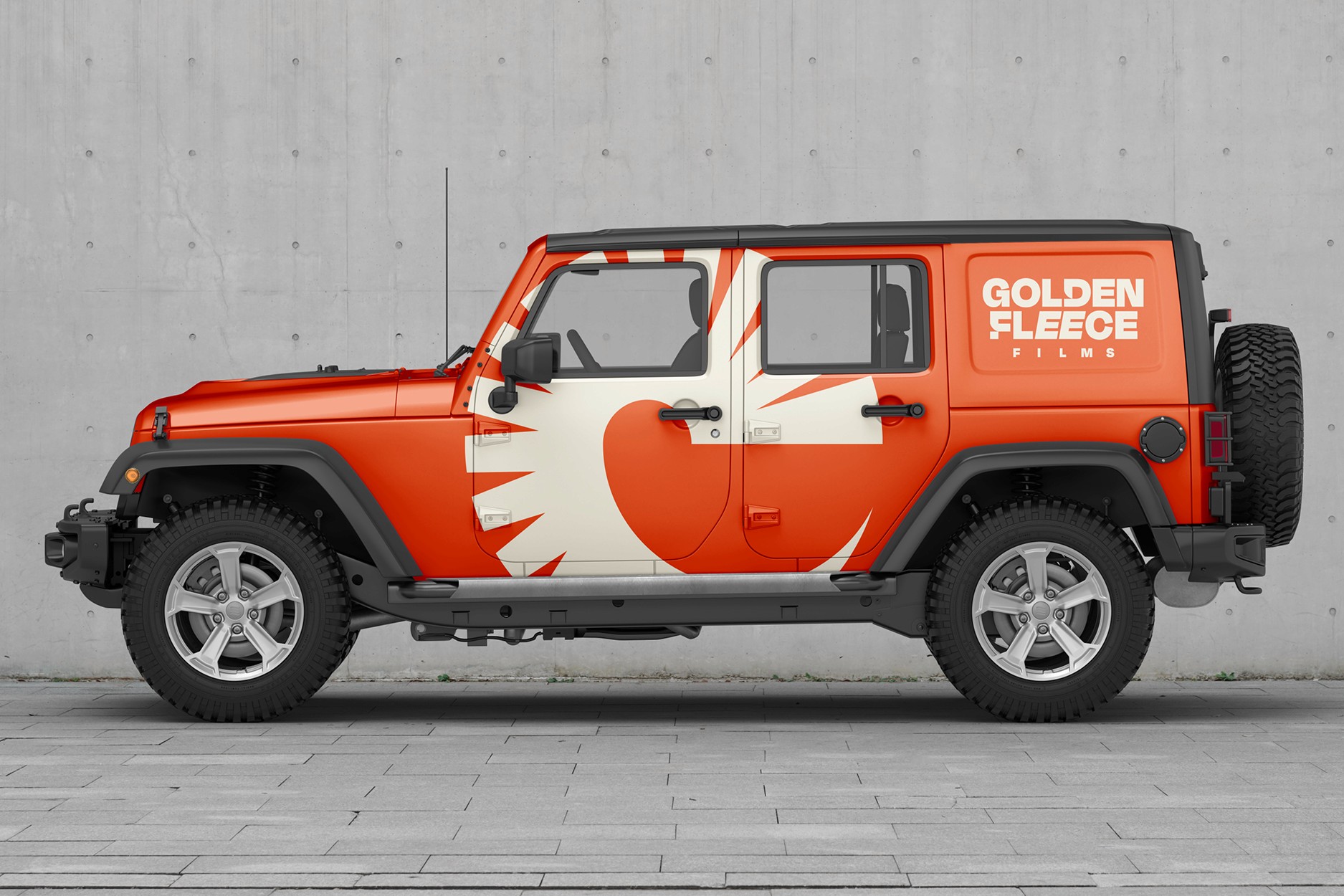 Golden Fleece Films branded Jeep with bold orange and white vehicle wrap featuring the company logo and sunburst symbol.