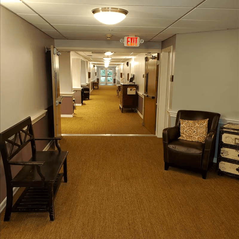 Memory care hallway with seating areas between resident rooms, encouraging conversation and connection.
