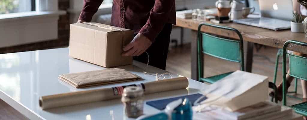 uomo che prepara un pacco da spedire all'estero