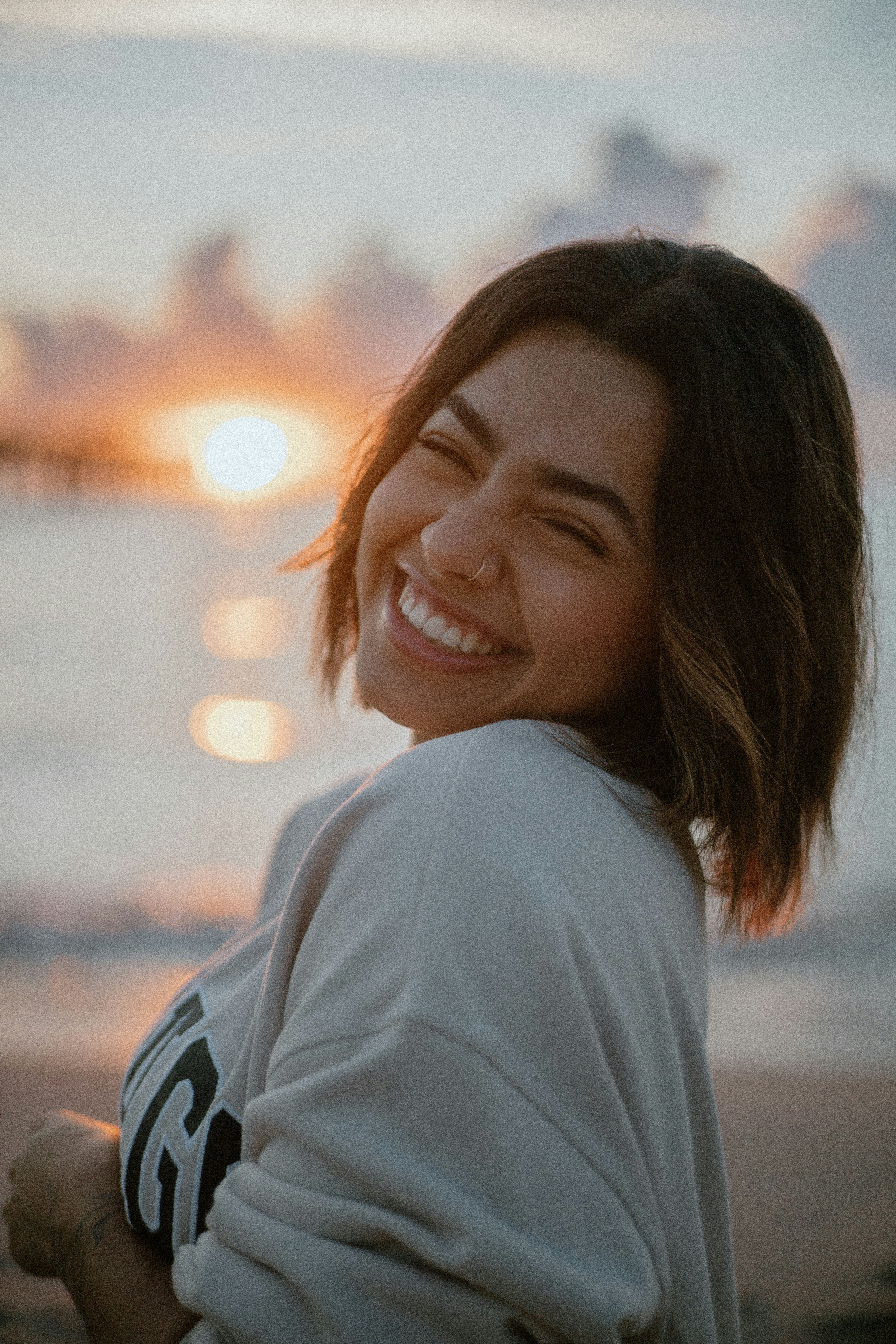 a woman smiles as she stands on the beach