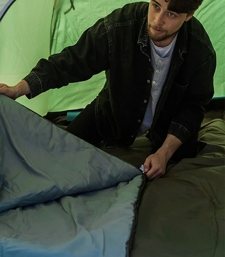 Homme pose matelas dans tente