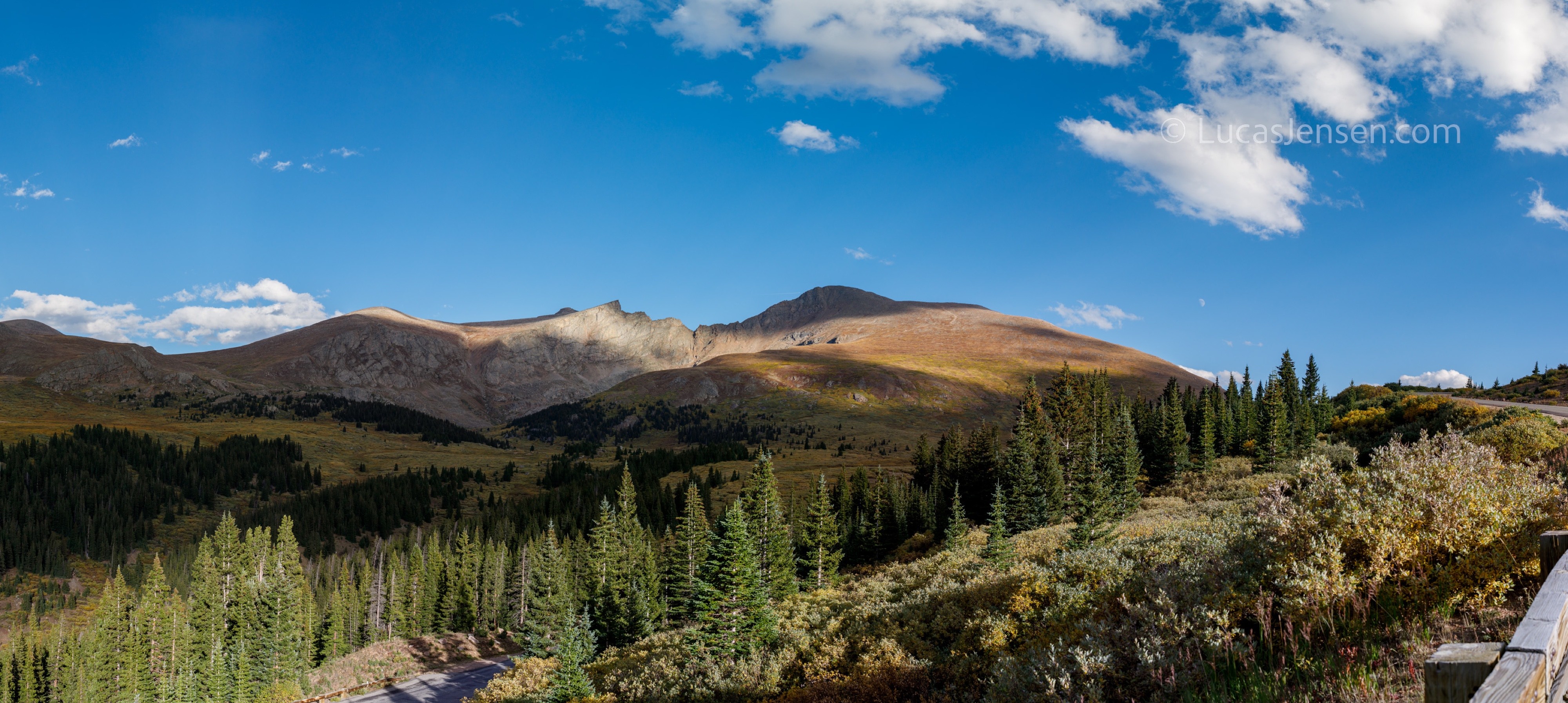 Panoramic landscape photograph of mountains, water, desert, or coast by Lucas Jensen