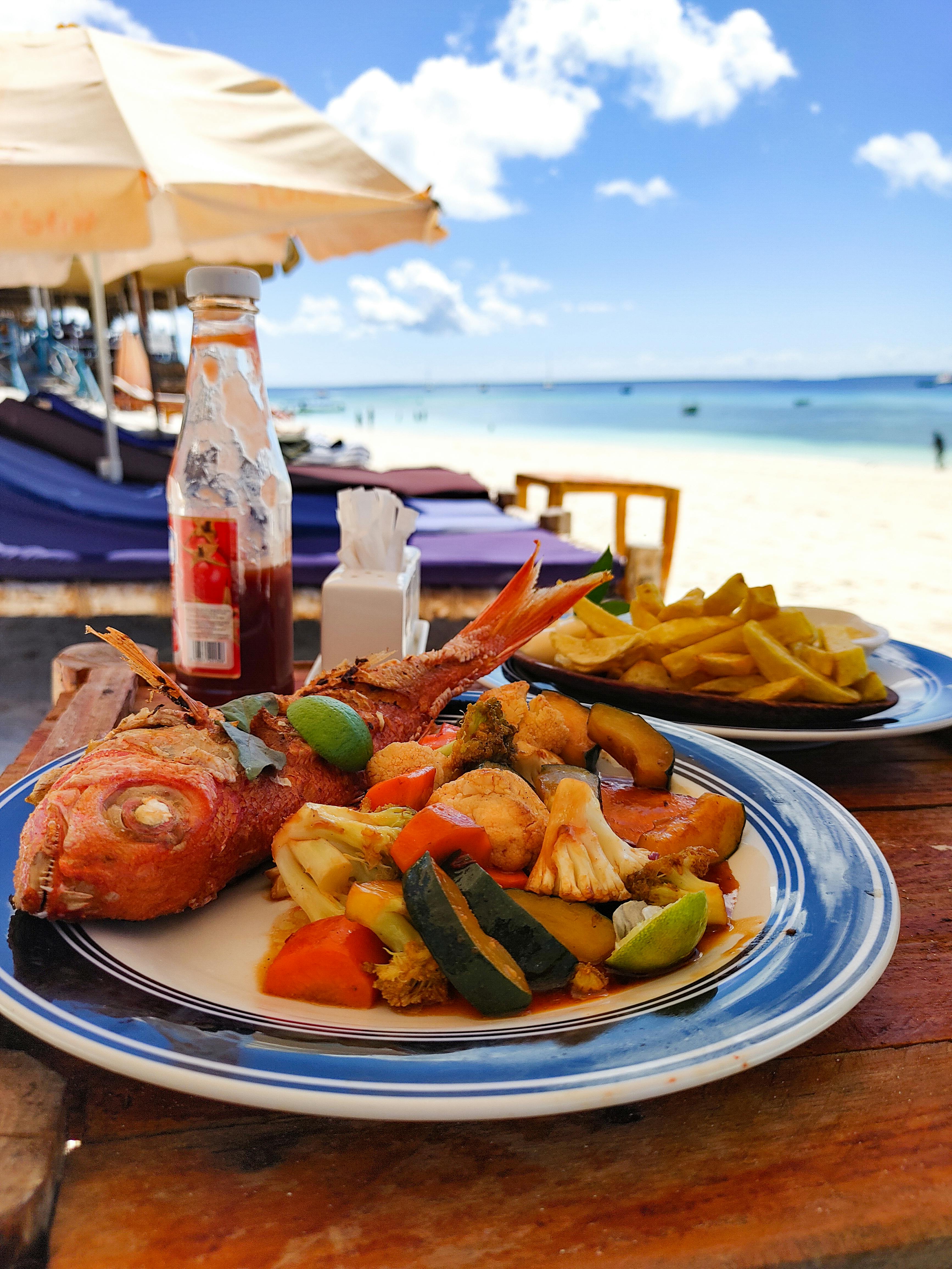 a plate of food on a table with a person looking at it