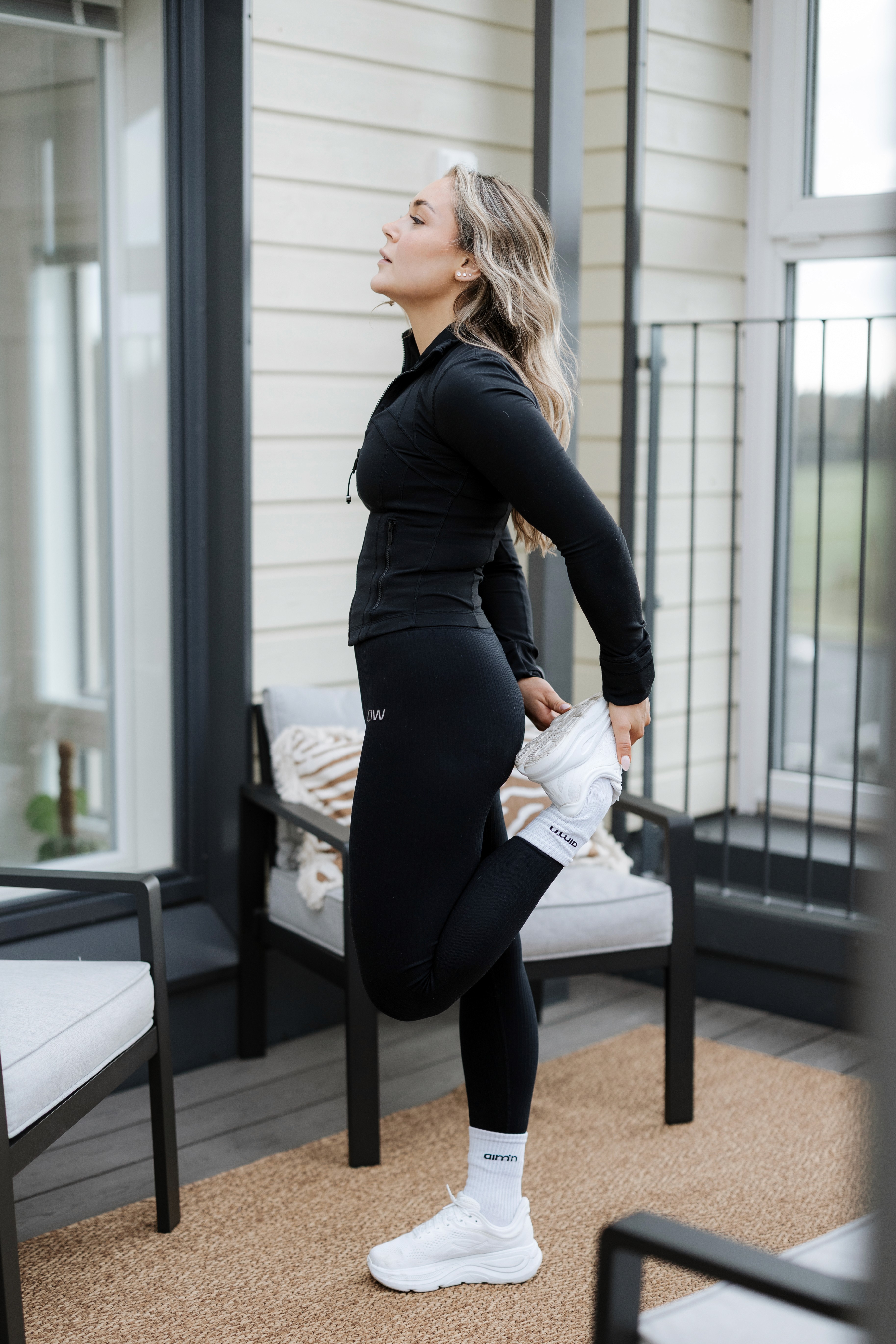 A woman stretching their leg outside.