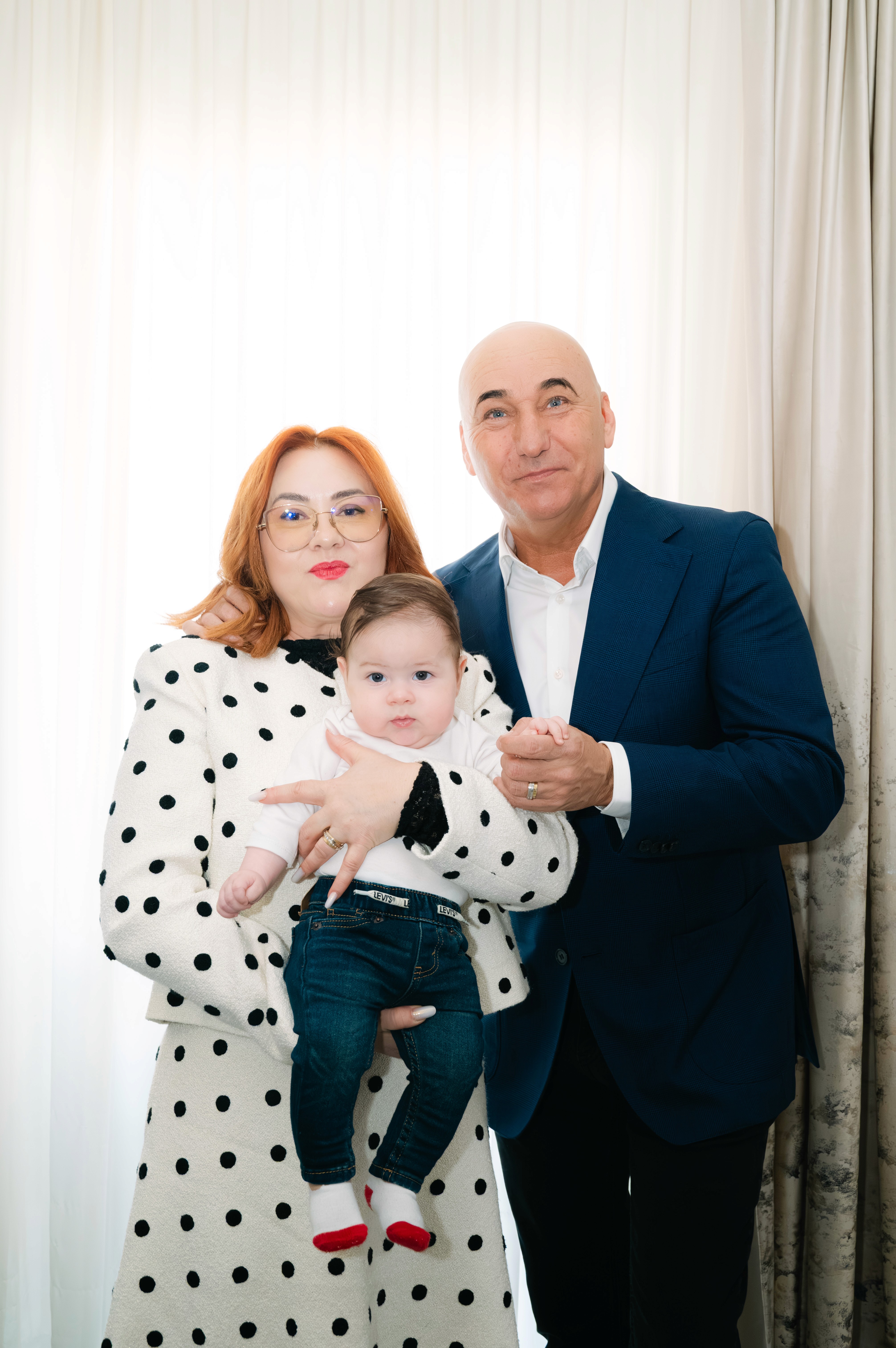 Nasii tinand copilul in brate inainte de botez