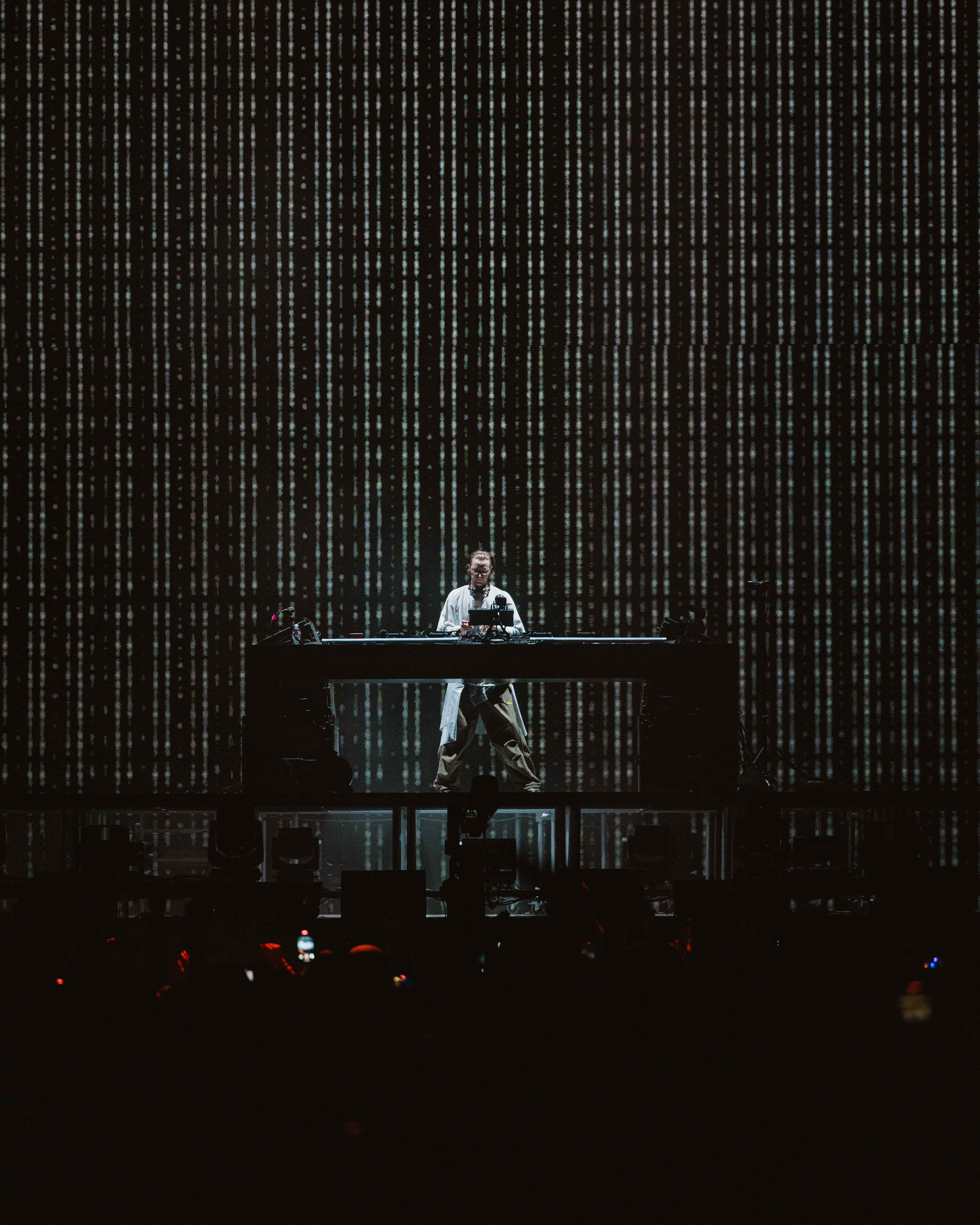MAU P performing live at Coachella 2025 behind the decks with a digital light backdrop, captured by A World Away creative director Brandon Densley