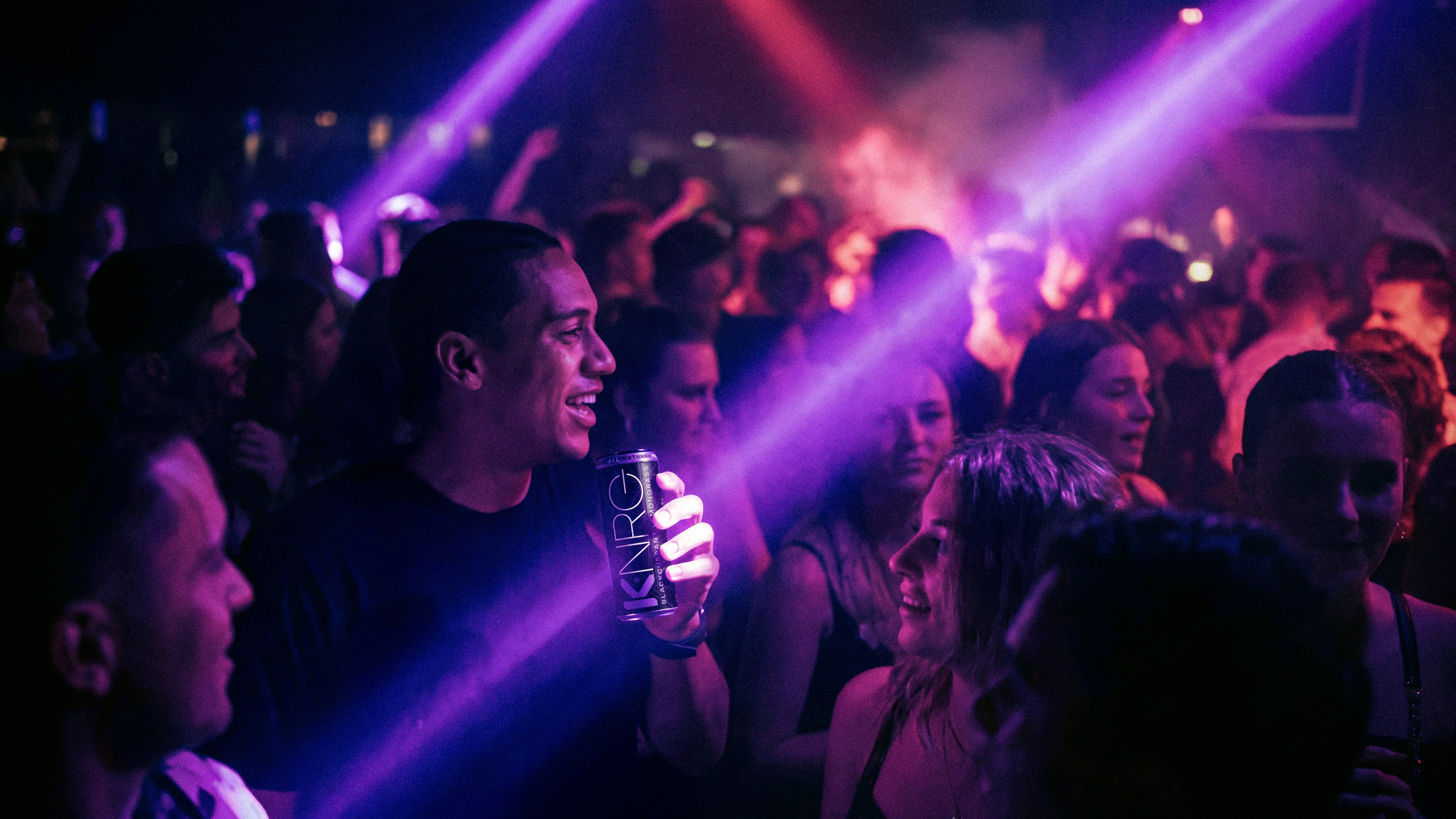 KNRG cast under purple nightclub lighting.