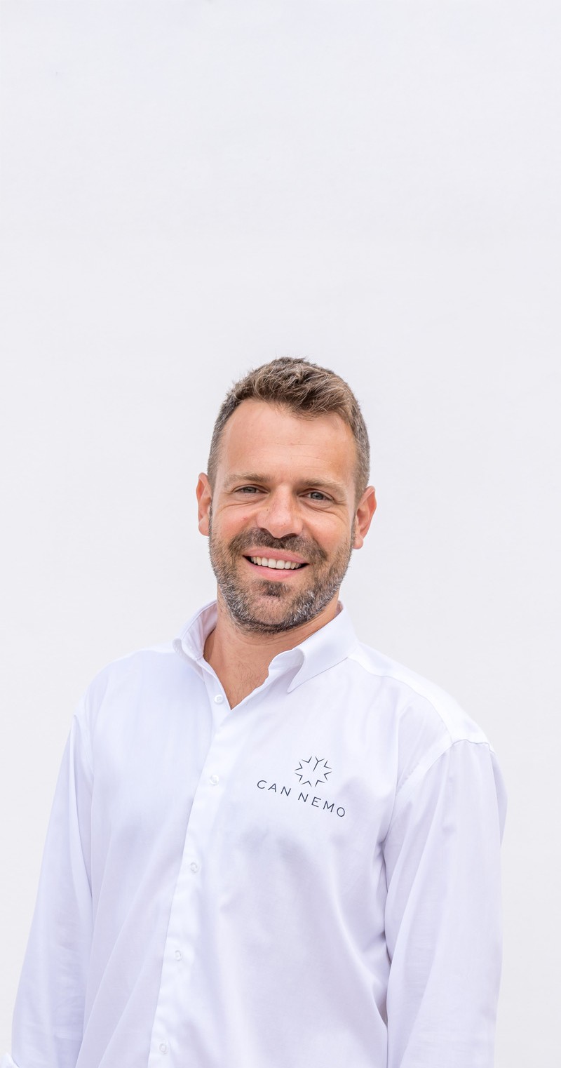 Portrait of villa manager in Can Nemo uniform representing professional estate-led service.