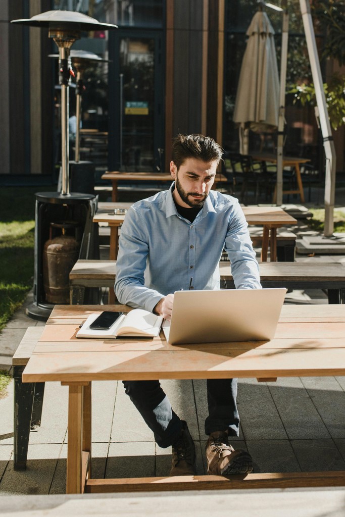 Newcomer working on a laptop at a cafe, building financial stability and credit in Canada