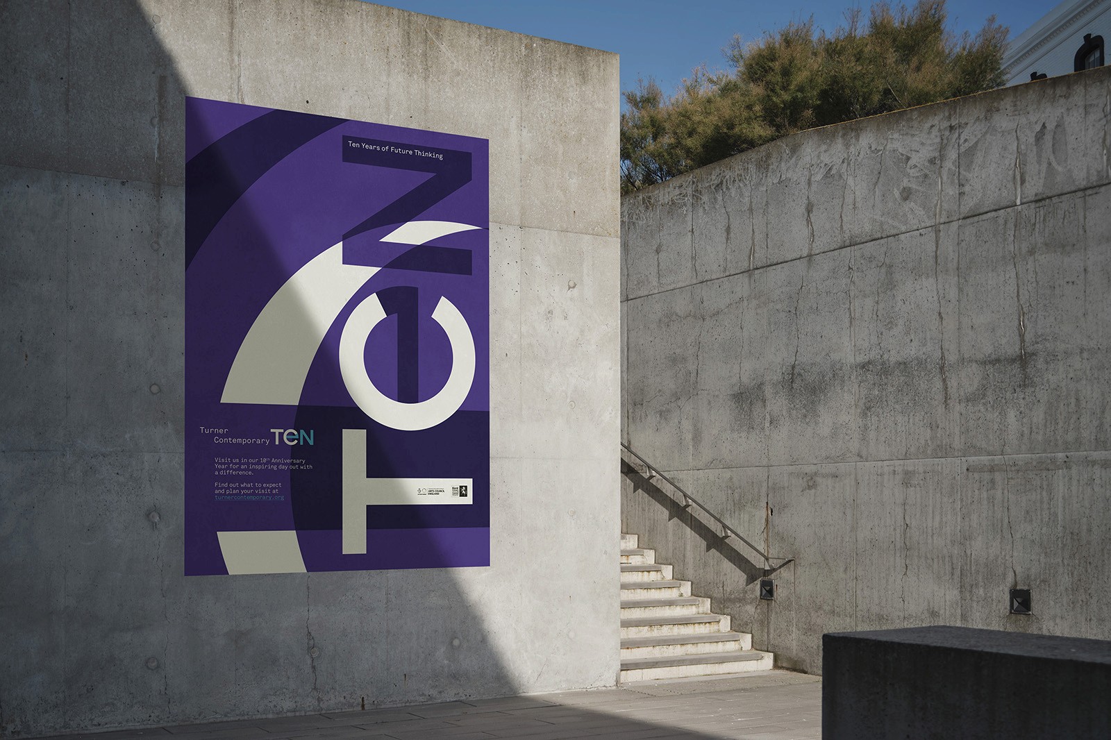 A purple banner with "TC TEN" is prominently displayed on a concrete wall in an outdoor setting.