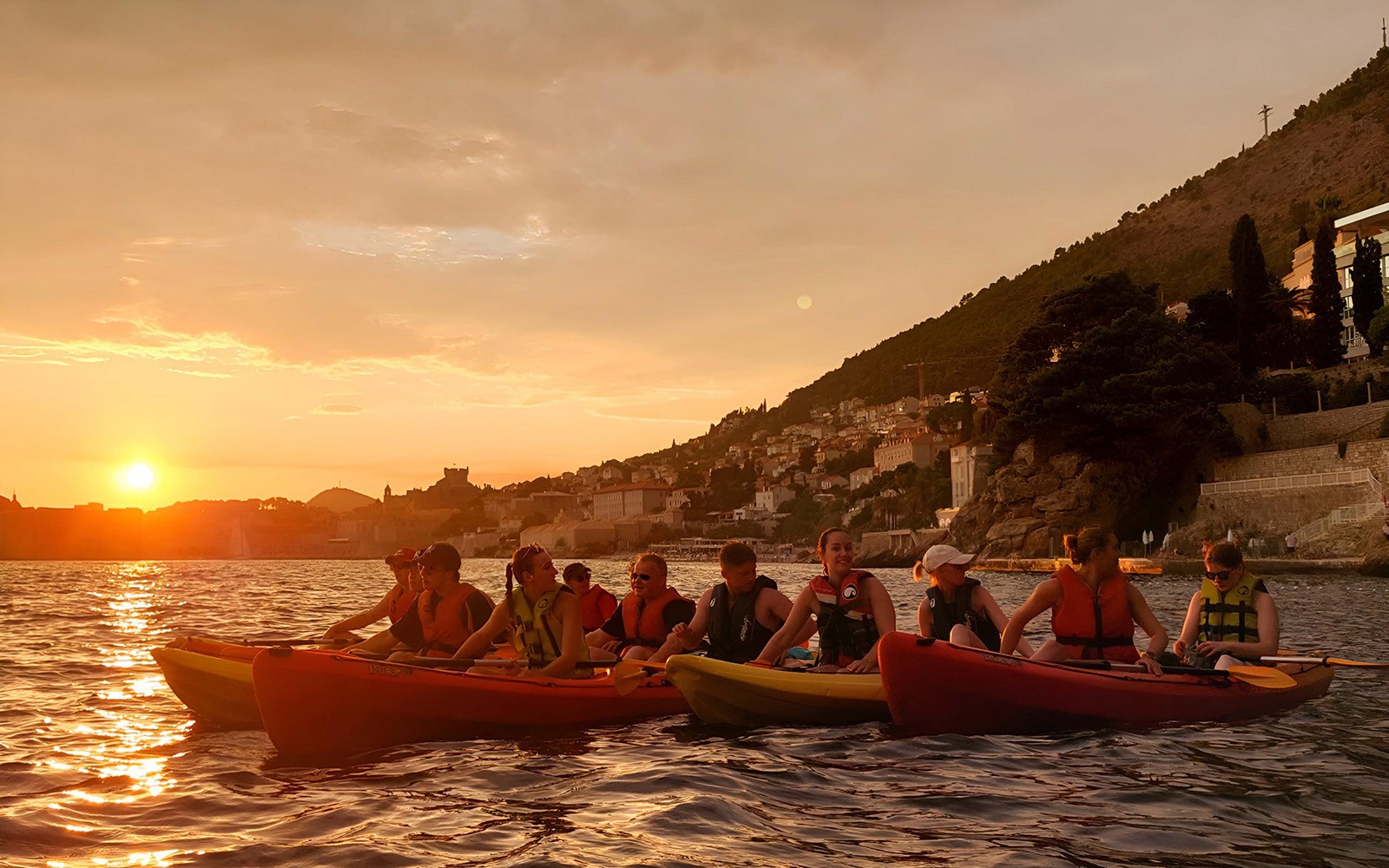 Kayakers at sunset near Old Town Walls, Betina Cave Beach, and Lokrum Island.