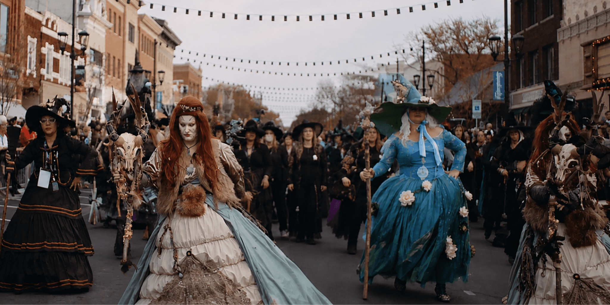 Elaborately costumed witches lead the Sandusky Witches Walk parade through downtown streets lined with spectators.