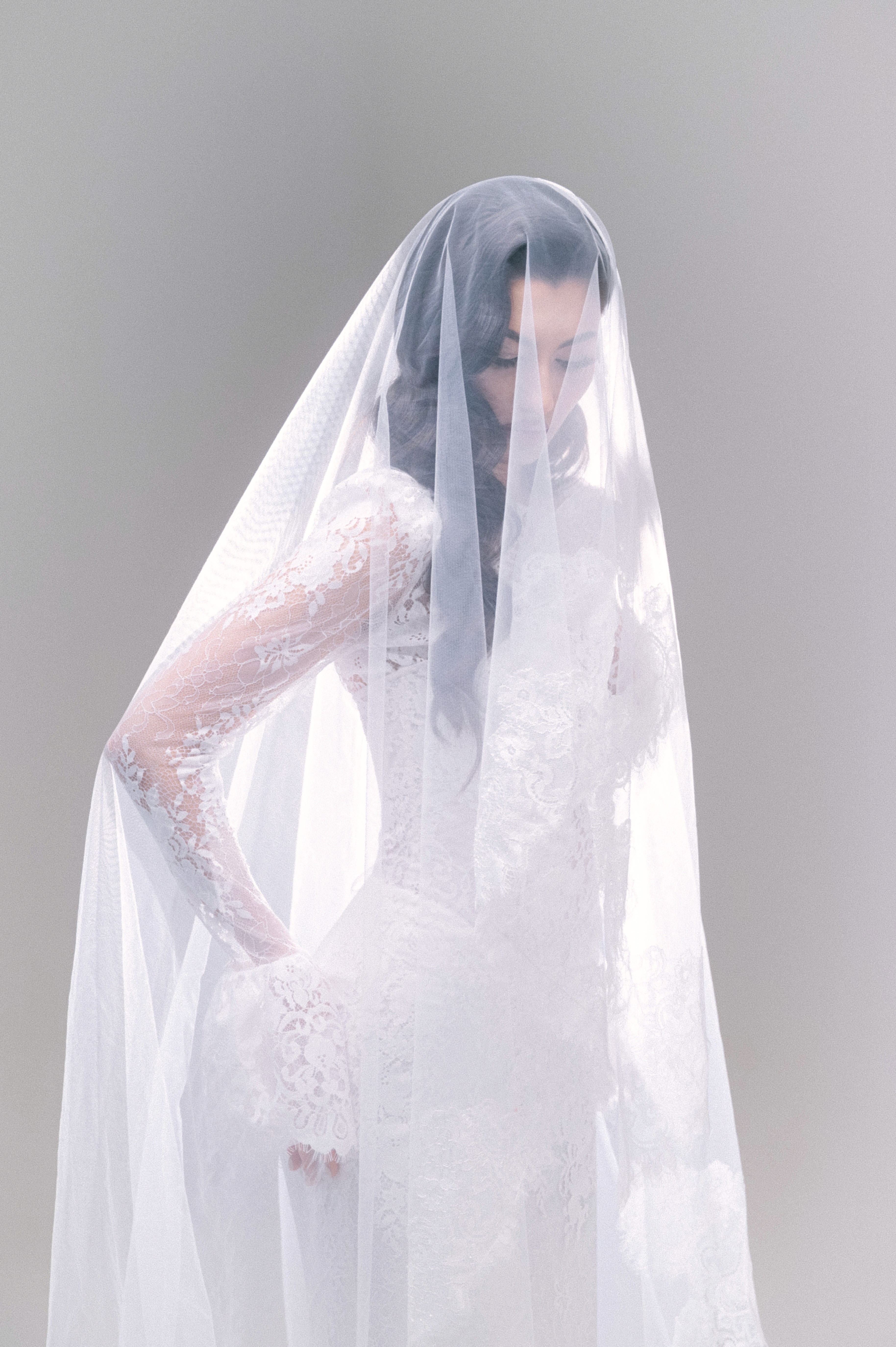 Detaliu artistic cu voal și mâna miresei într-o lumină soft, fotografie de nuntă în București