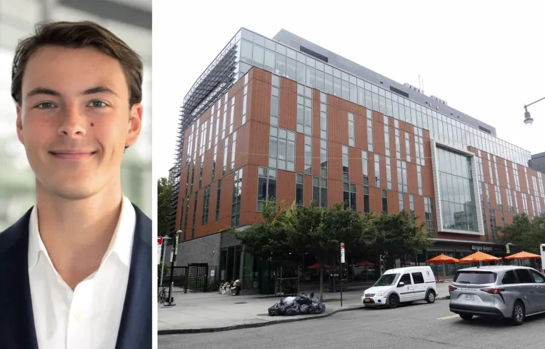 Tall modern skyscraper with vertical lines, viewed against a clear blue sky.