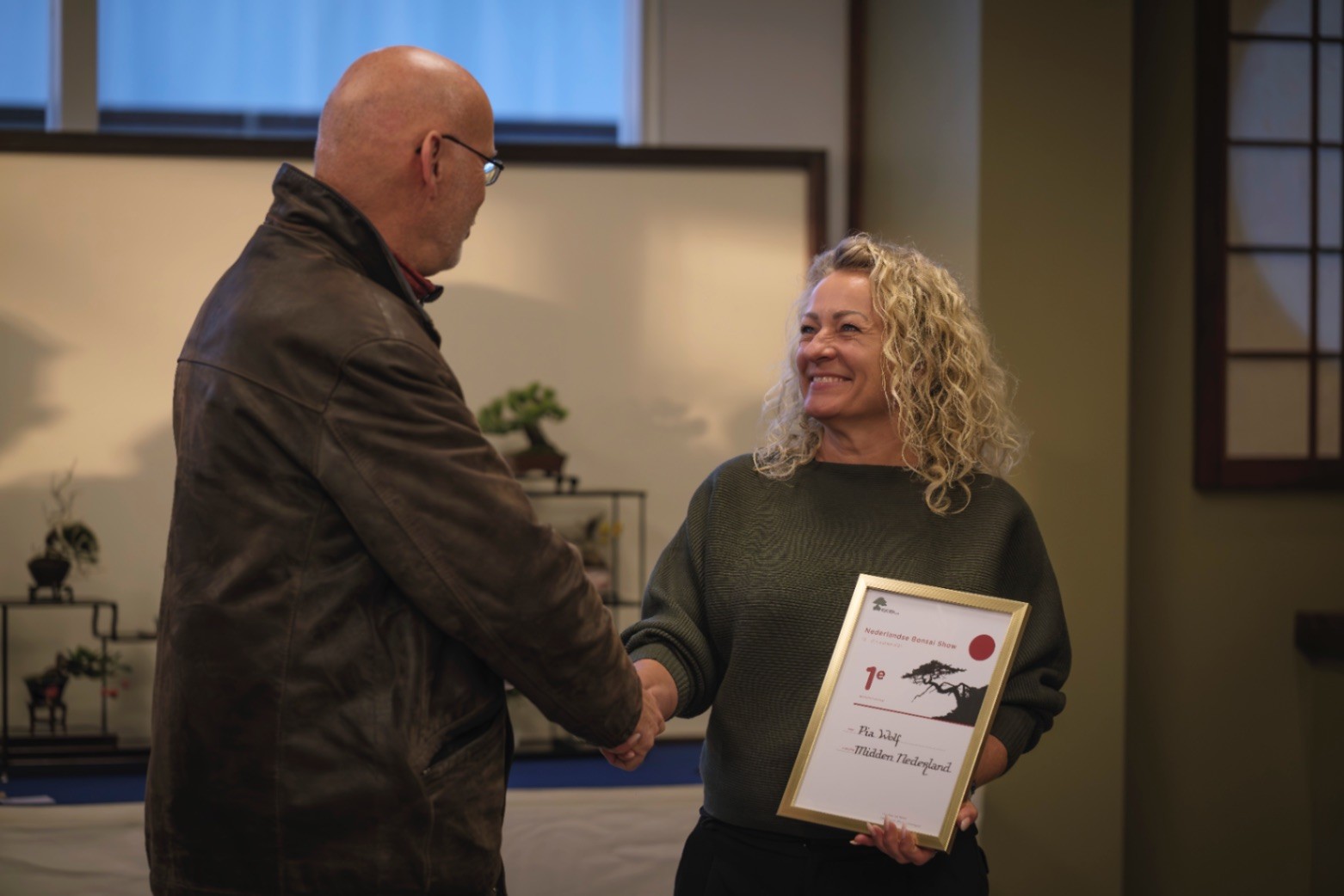 2 leden die aan een bonsai boom werken