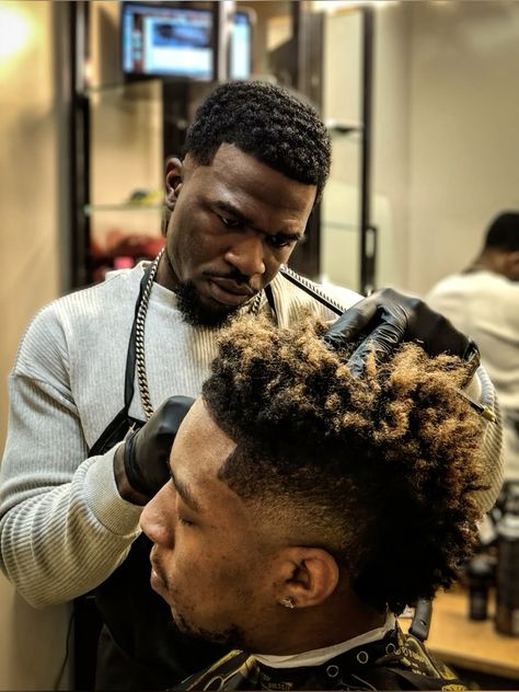 Coiffeur qui s'occupe des cheuveux de son client