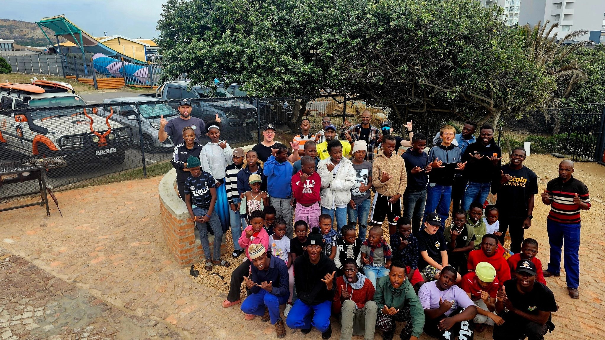 Eric Sirion with a large group of Bitcoin Ekasi community members and children gathered outdoors in Mossel Bay, South Africa