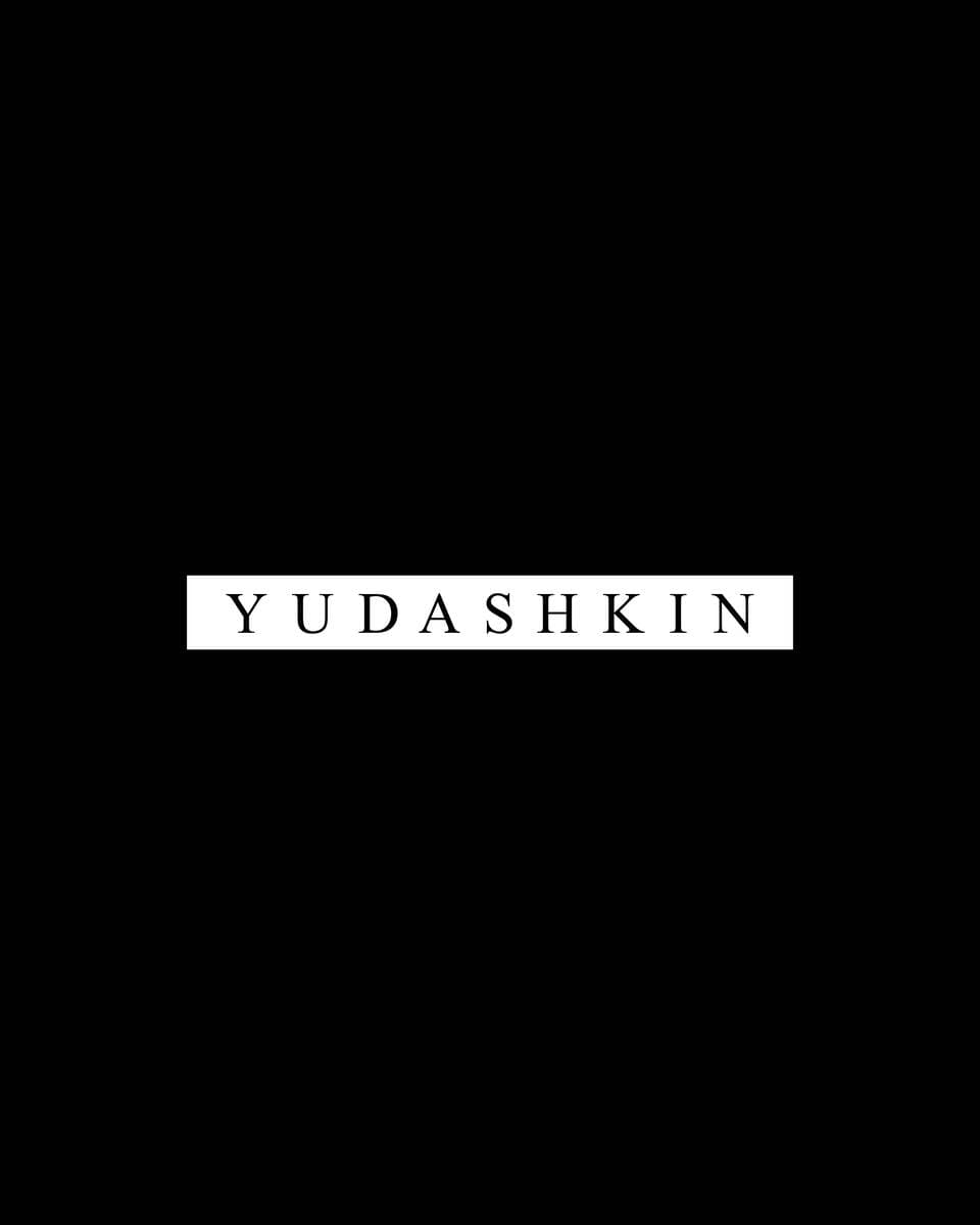 Logo yudashkin against a dark background.