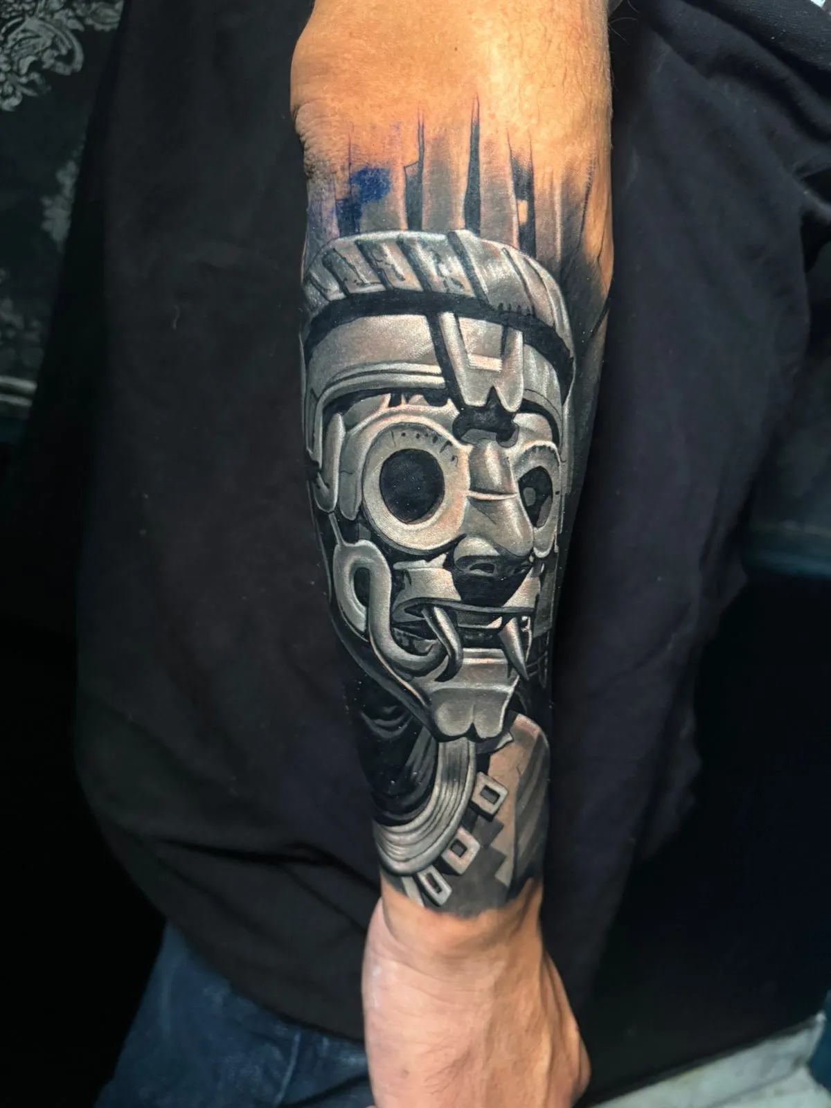 Black and grey Aztec warrior mask tattoo on forearm at Calavera Ink Berlin
