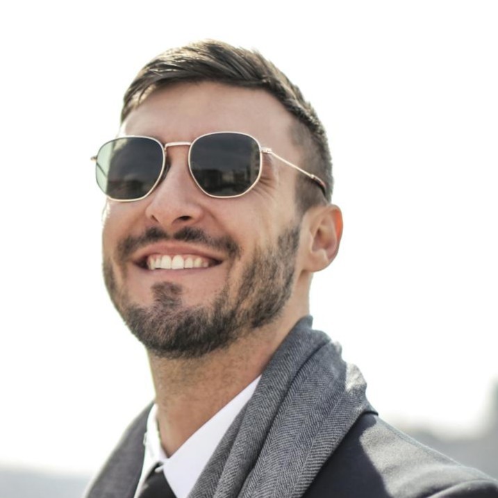 A man standing in front of a window smiling