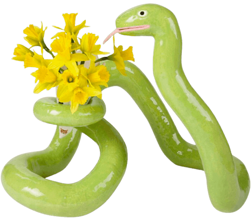 Ceramic snake vase with yellow daffodils — quirky element on GUFR’s shelf, symbolizing unexpected growth and transformation with humor.