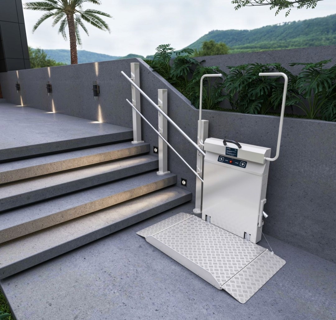 Stanchion-mounted outdoor vertical platform step lift with aluminium checker plate platform deployed at the base of contemporary concrete entrance steps