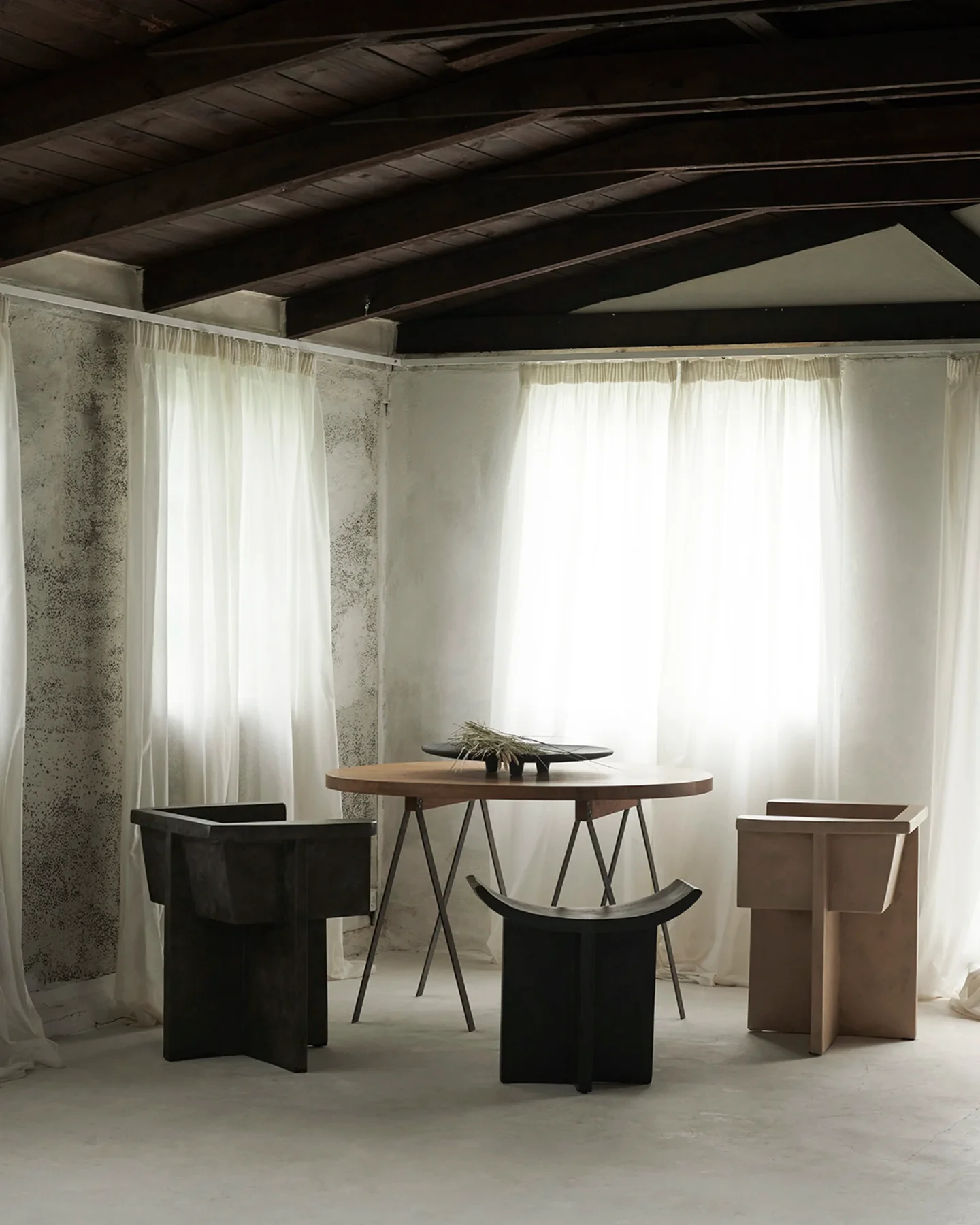 Minimalist beige bedroom with an open shower area, low platform bed, wooden bench, and soft natural lighting.