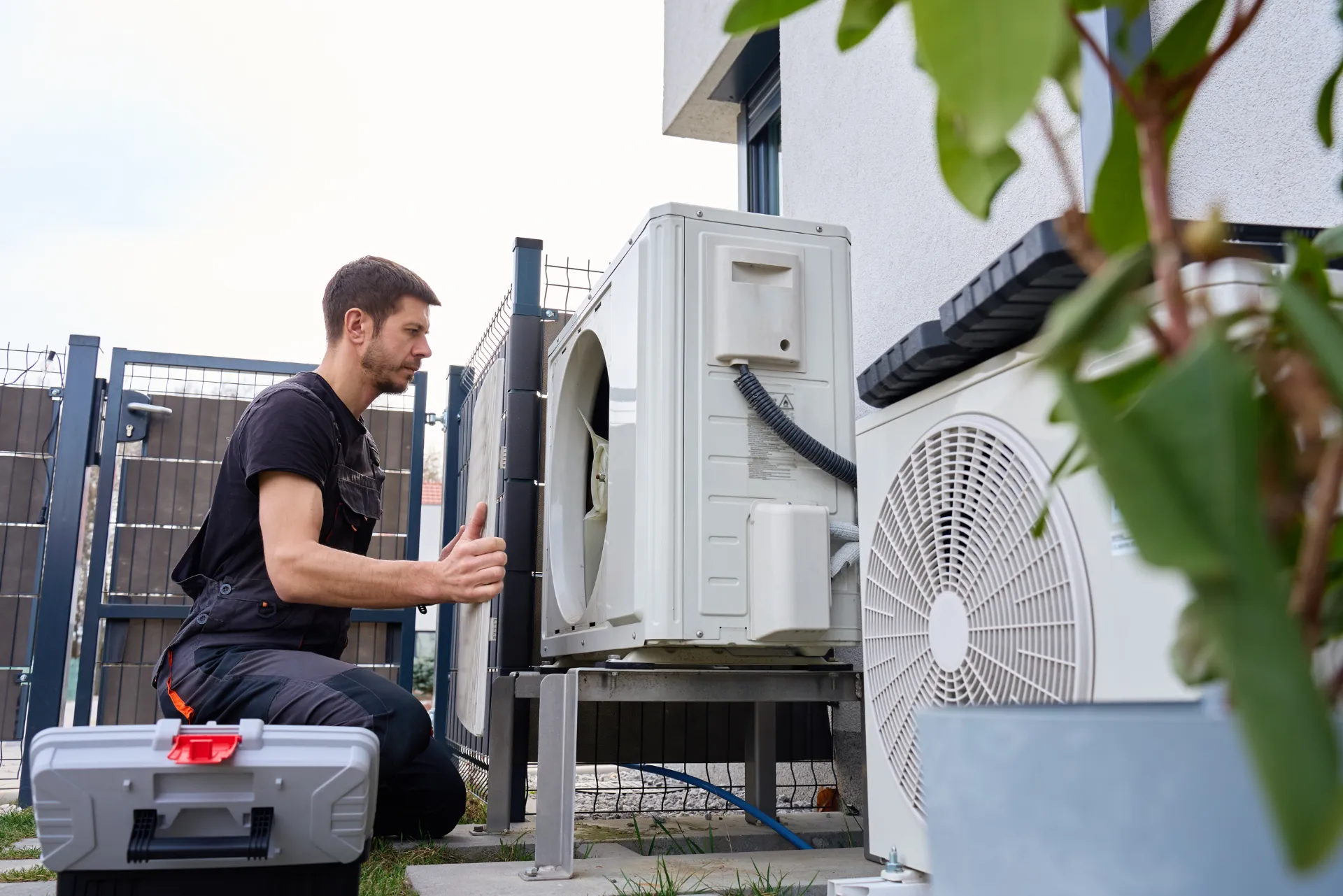 Ein Installateur vor einer Sole-Wärmepumpe.