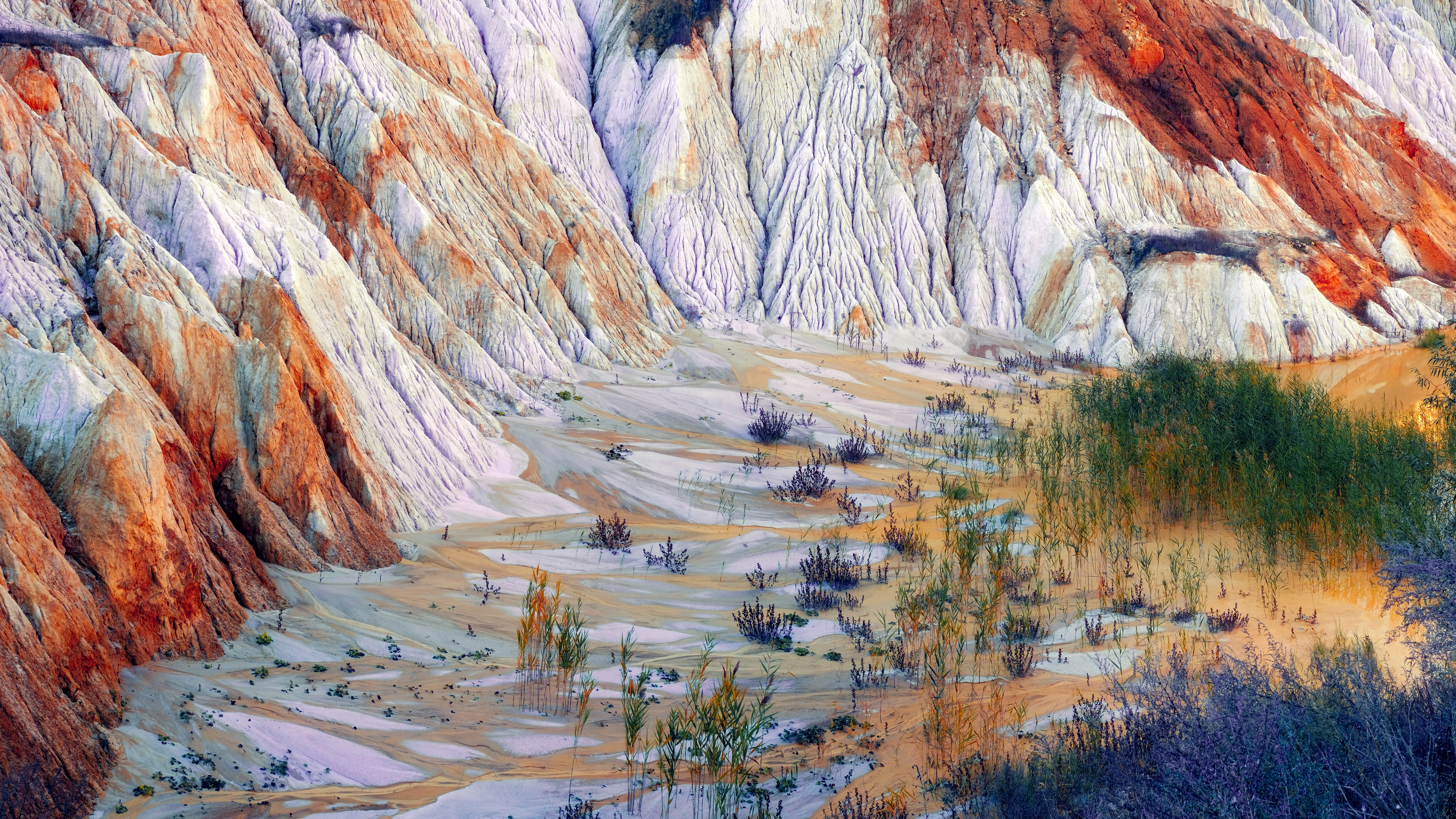 A high-angle composition of natural rock formations, emphasizing layered textures, tonal contrast, and the sculptural rhythm of the landscape.