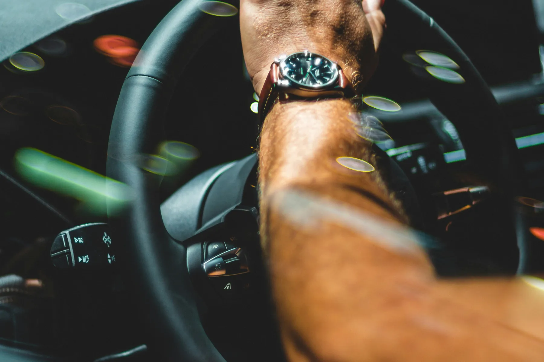 Mão ao volante com luzes nocturnas em bokeh — Táxi Afonso · 06 Caminha