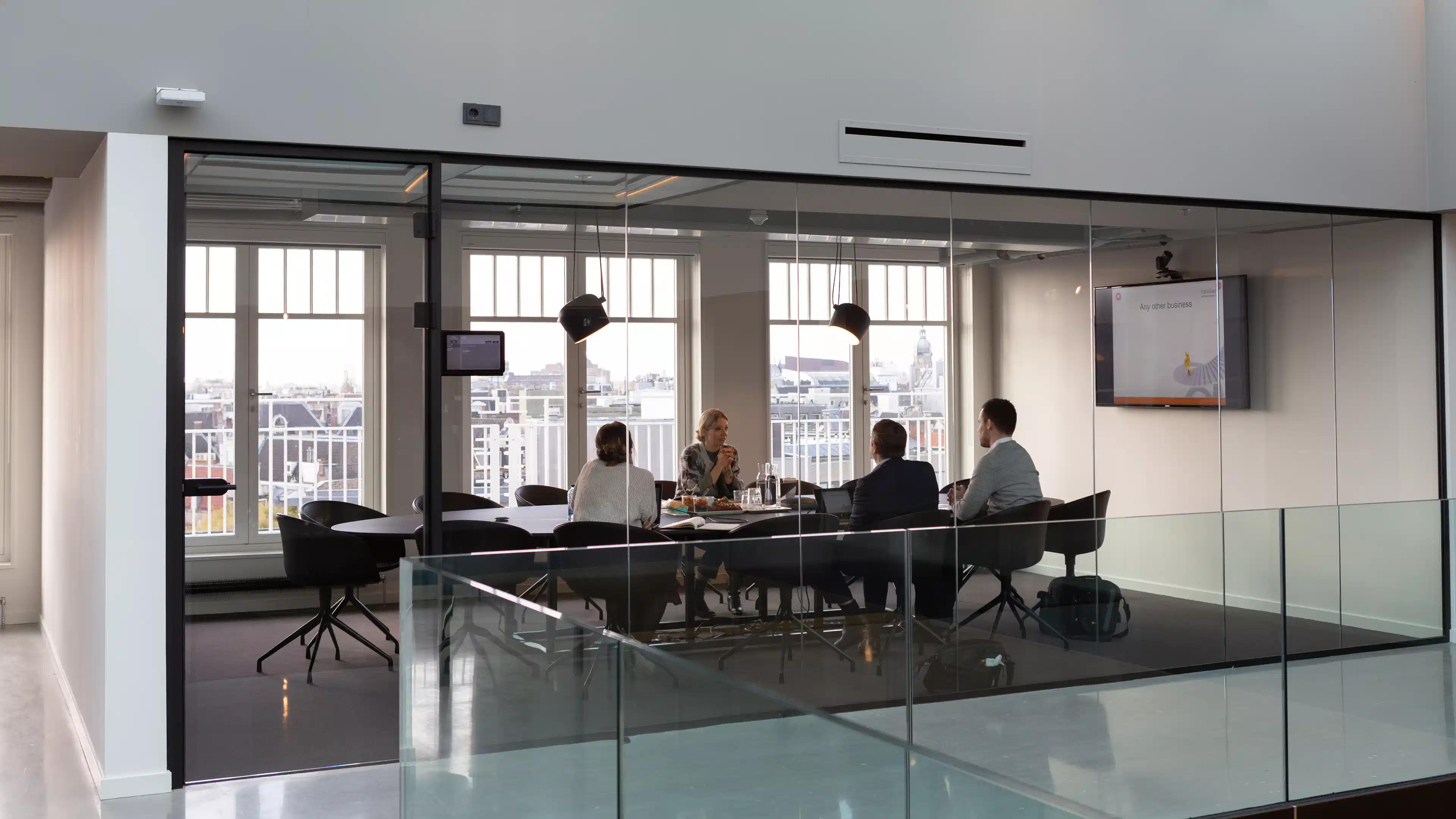 Modern office meeting room with glass walls. Business meeting in progress.
