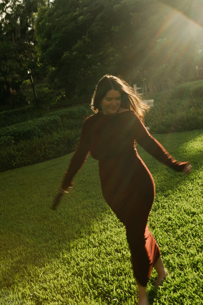    Wedding photographer in South Florida walking through a garden in golden evening light.