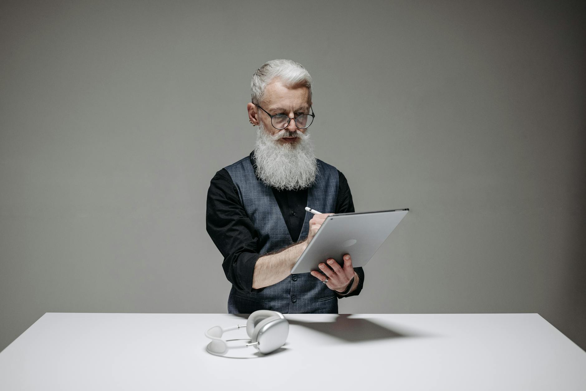 A professional wearing a headset types on a laptop displaying a split-screen video conference with multiple students.