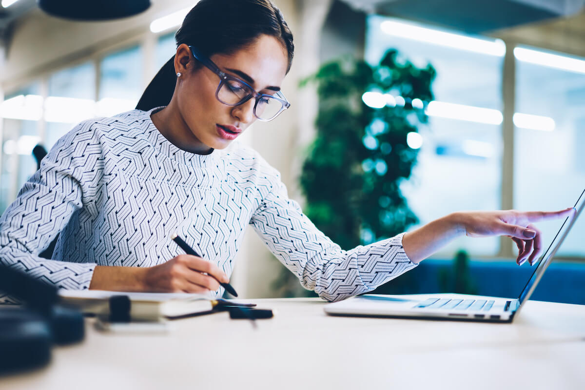 BANT: woman comparing data from her computer vs. her notes