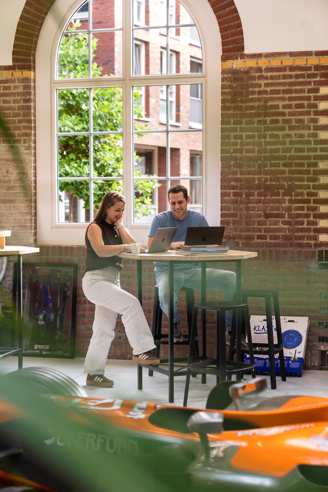 they are working at a high table without backrests ouch that has to be uncomfortable