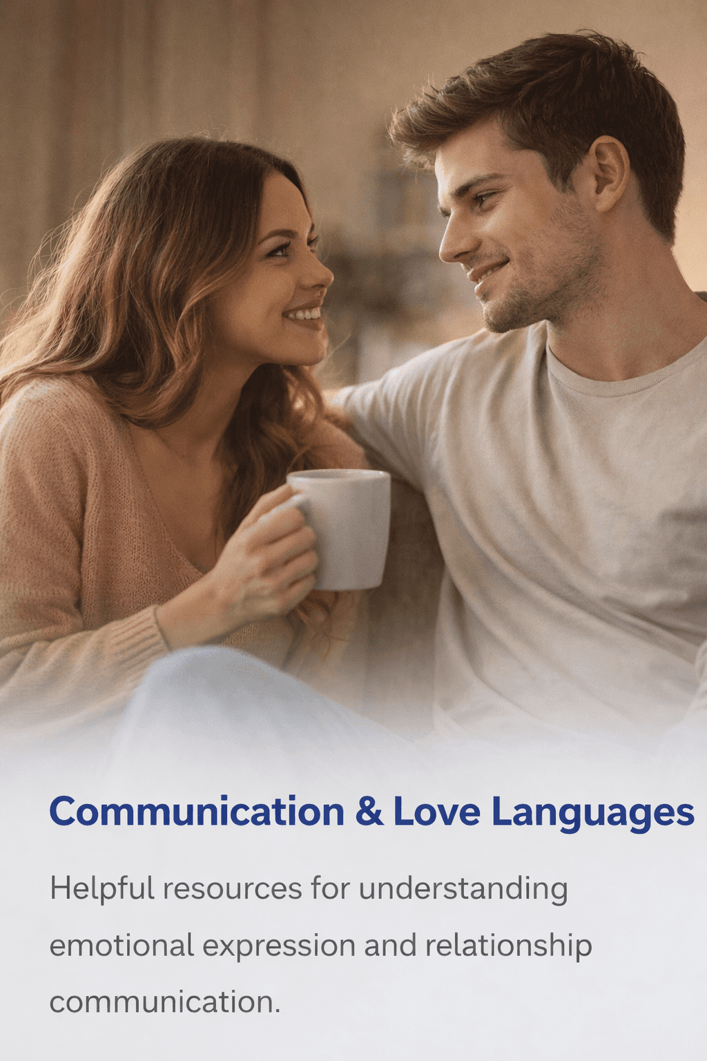 A man and a woman sitting together on a couch, holding mugs and looking at each other with warm, engaged expressions during a conversation.