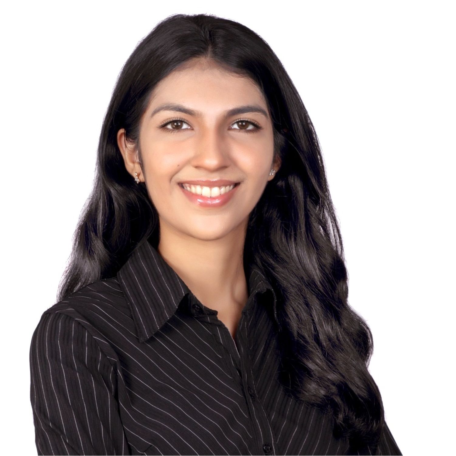 A woman with short curly hair wearing a black t-shirt looks into the camera.