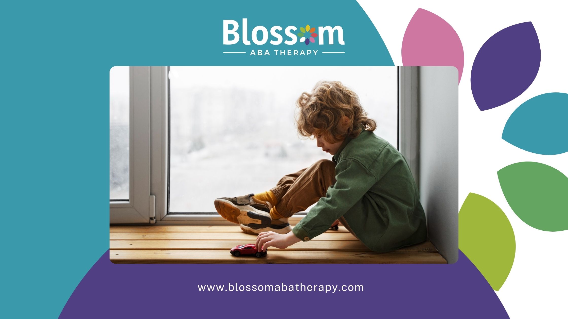 Child sitting by window playing with toy car on wooden floor.