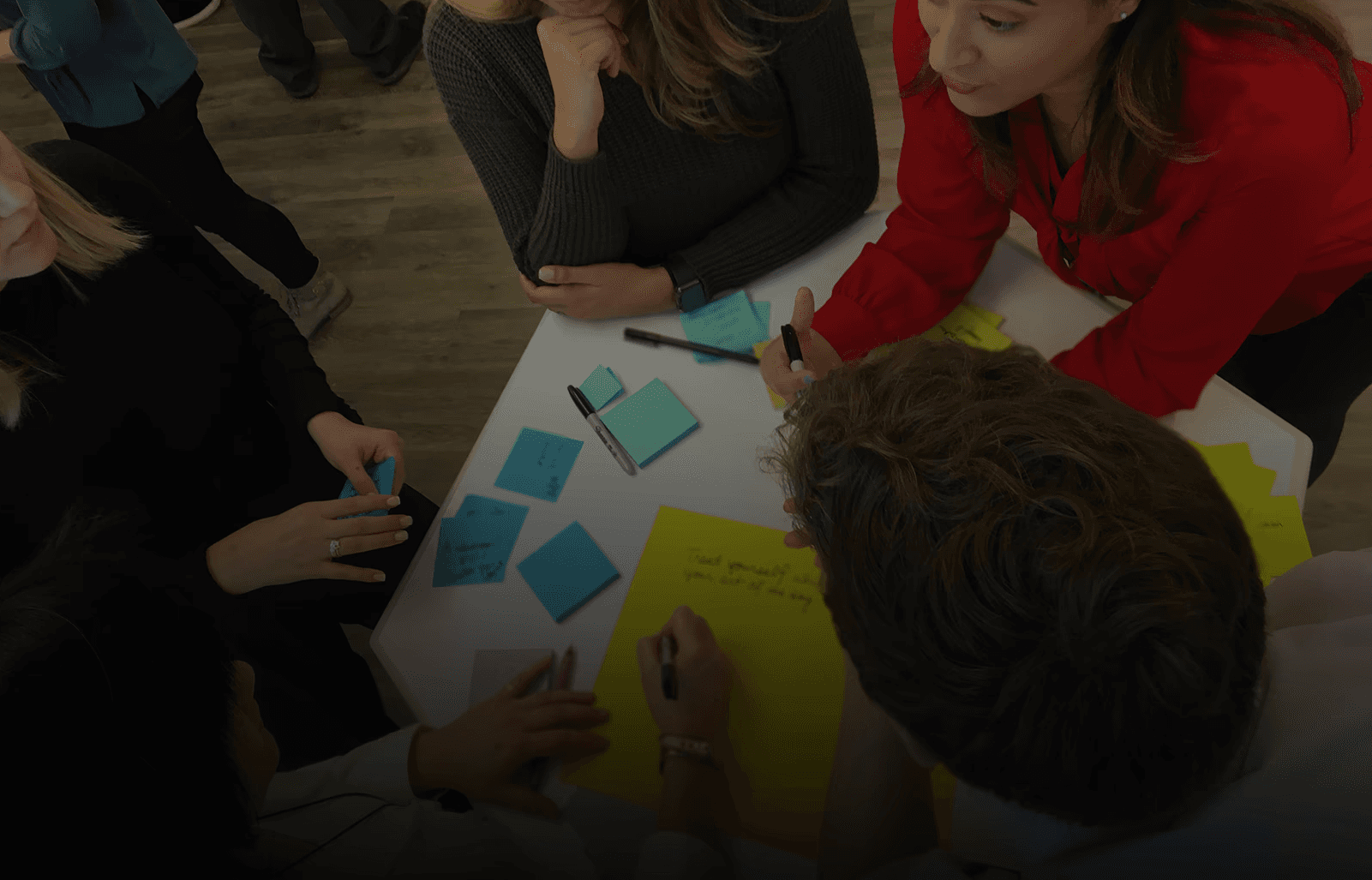 Leaders gathered around a table during a Public Works Tools & Tactics session, collaborating in a human-centered design session to strengthen organizational agility.