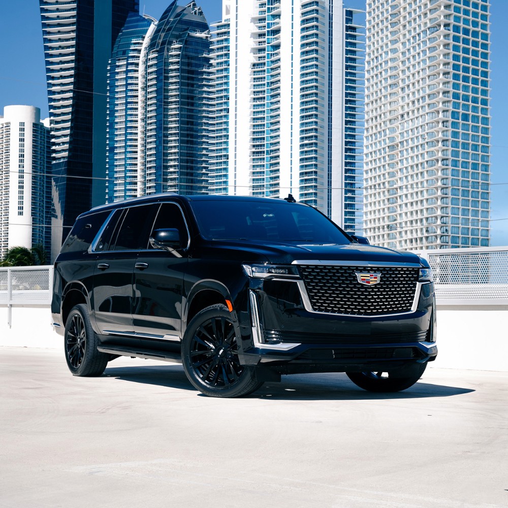 Cadillac Escalade ESV in black parked on a rooftop in Miami with city skyline in the background