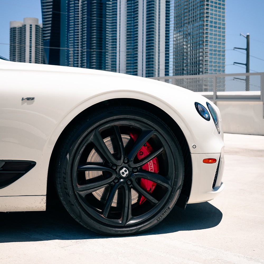 Close-up of Bentley’s black alloy wheel with red brake caliper detail