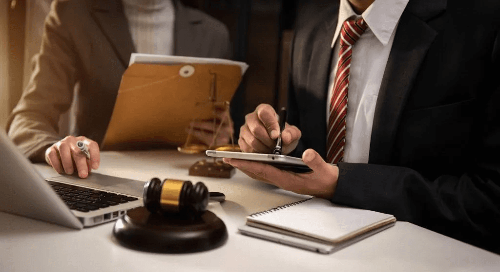 two people in front of a laptop deliberating over a case in the judicial system