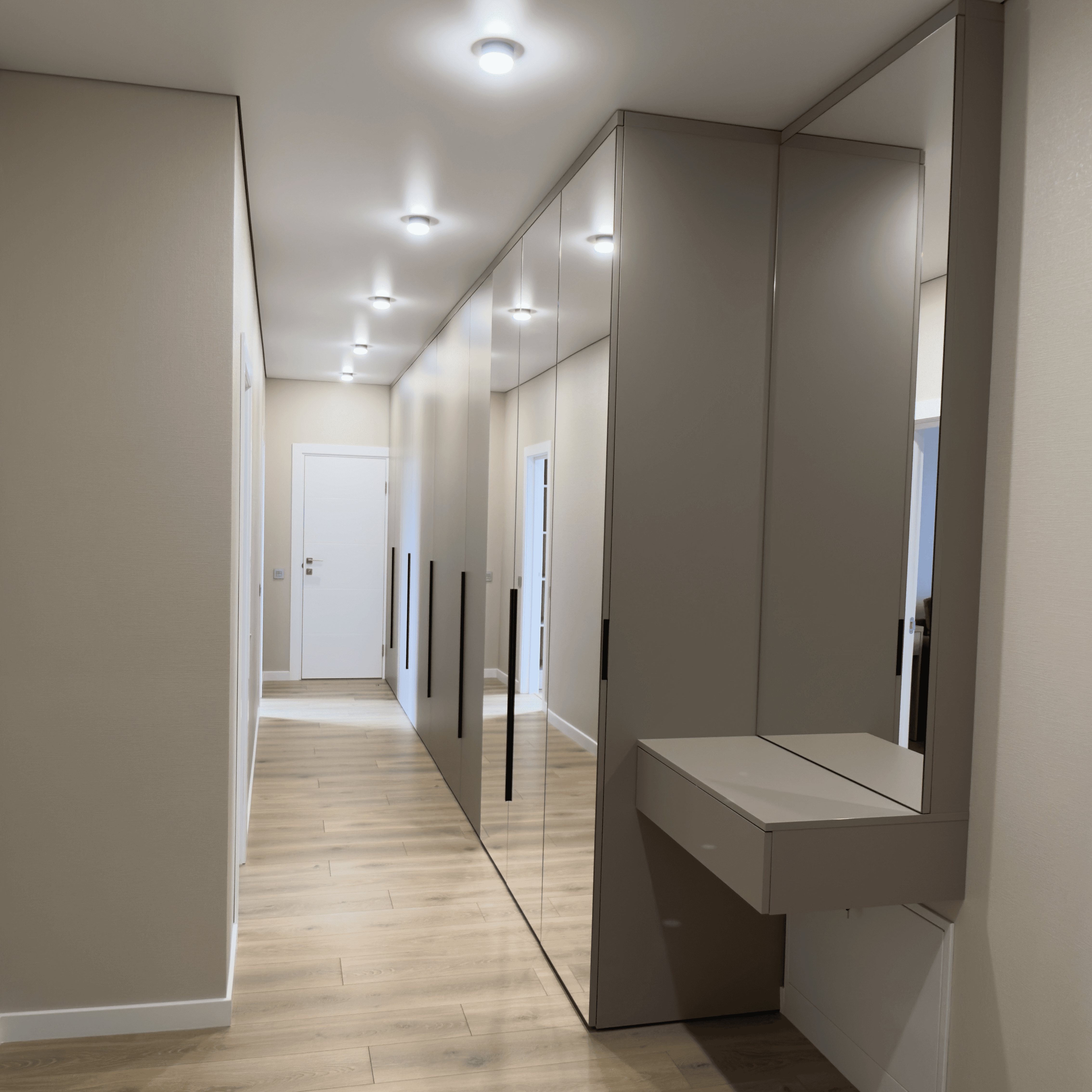 Довгий коридор із дзеркальними шафами, глянцевими фасадами та вбудованим освітленням