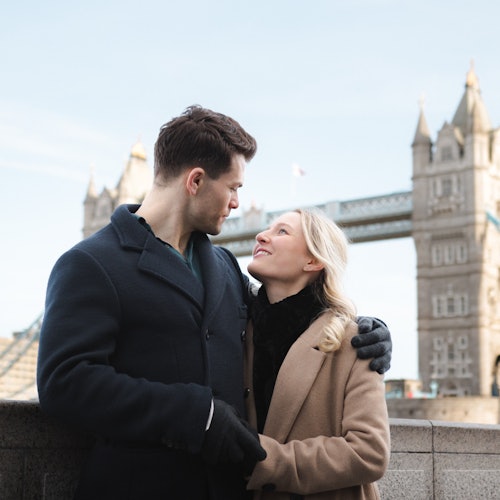 Pariskunta nauttimassa valokuvauksestaan kuuluisan Tower Bridgen edessä